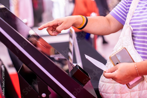 Selective focus to customer's hand is touching a touch screen and scan to ticket for pay parking or food with the new payment system. Payment electronically concept. photo