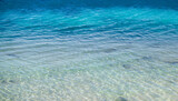 Ocean sea texture with calm clear water of lagoon near shore of tropical island, copy space in blue