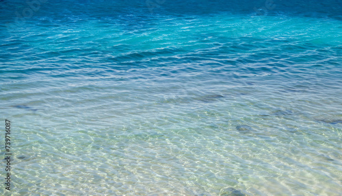 Ocean sea texture with calm clear water of lagoon near shore of tropical island, copy space in blue