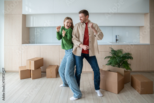 Obraz na plátně Dancing of joy and happiness, overjoy married couple have fun in spacious apartment with packed cardboard boxes