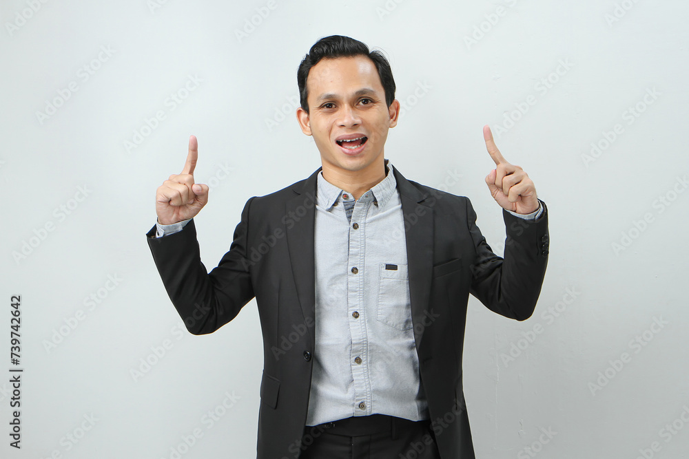 Happy confident asian indonesian business man in suit with pointing finger gesture on isolated background Happy confident asian indonesian business man in suit with pointing finger gesture on isolated background