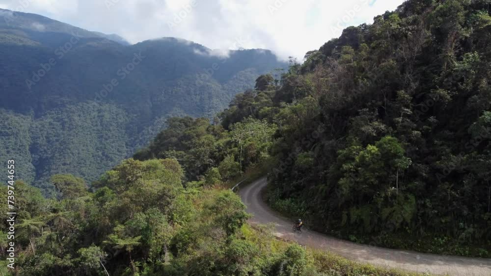 Cyclists descend world famous Yungas Road in steep mountains, Bolivia Cyclists descend world famous Yungas Road in steep mountains, Bolivia