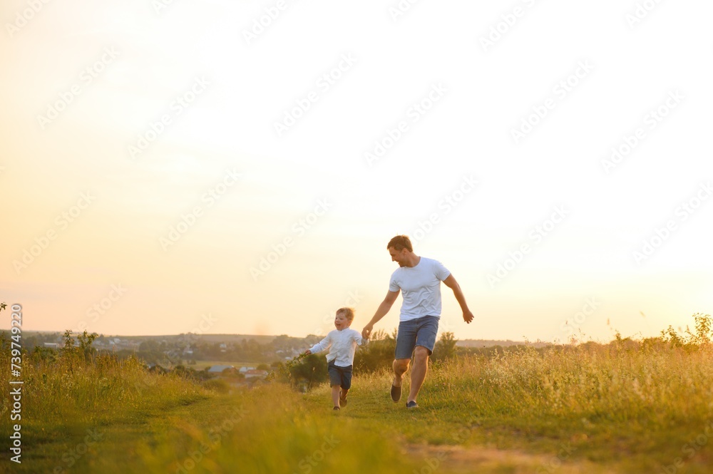 Happy father, son child running playing in the park outdoors together. Family, Father's Day, parenting, active lifestyle concept. Happy father, son child running playing in the park outdoors together. Family, Father's Day, parenting, active lifestyle concept.