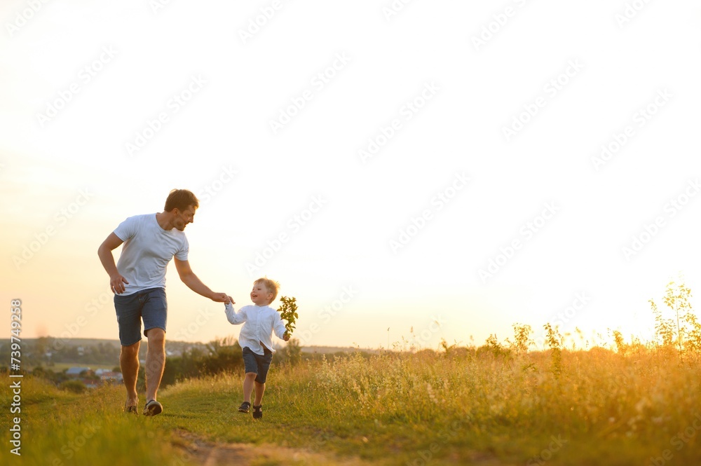 father's day. Dad and son playing together outdoors on a summer. Happy family, father, son at sunset.