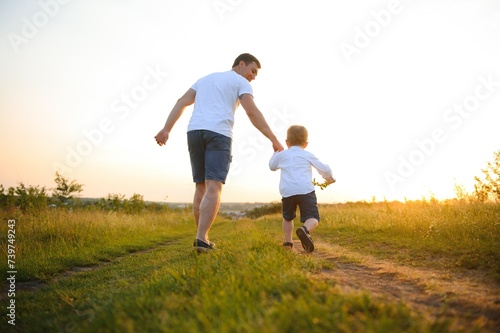 Father's day. Happy family father and toddler son playing and laughing on nature at sunset