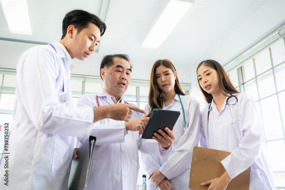 A medical professor and medical student discuss a case study involving disease therapy for a hospital patient. A medical professor and medical student discuss a case study involving disease therapy for a hospital patient.