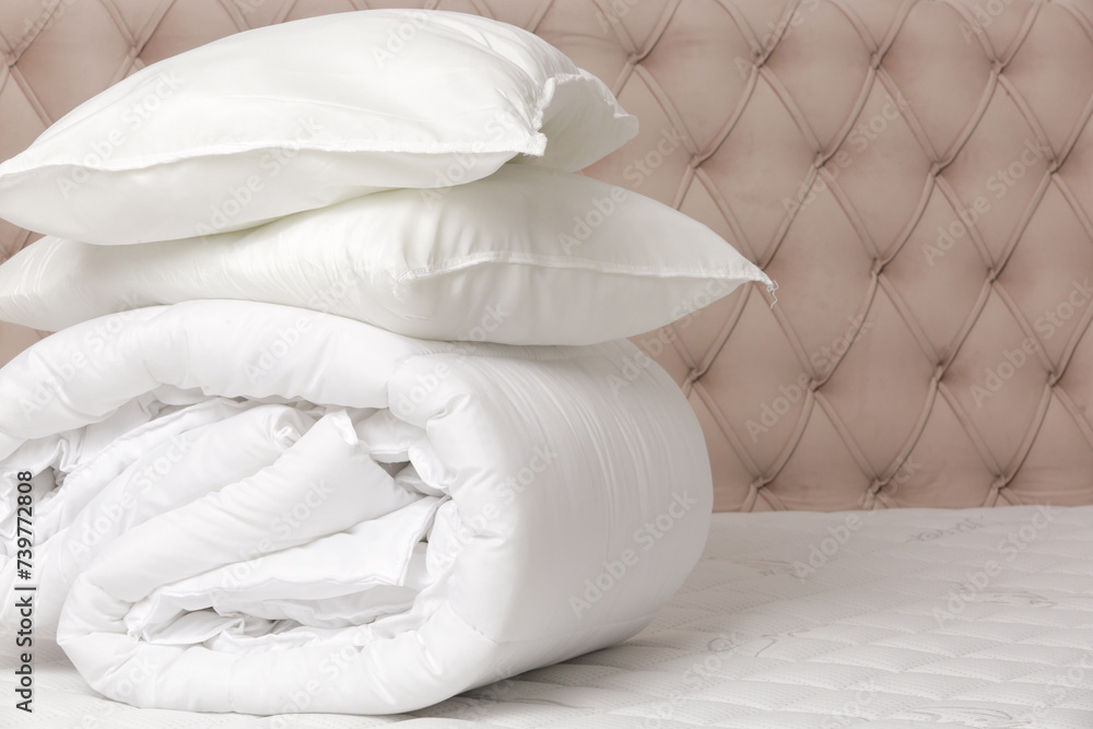 Soft folded duvet and pillows on bed Soft folded duvet and pillows on bed
