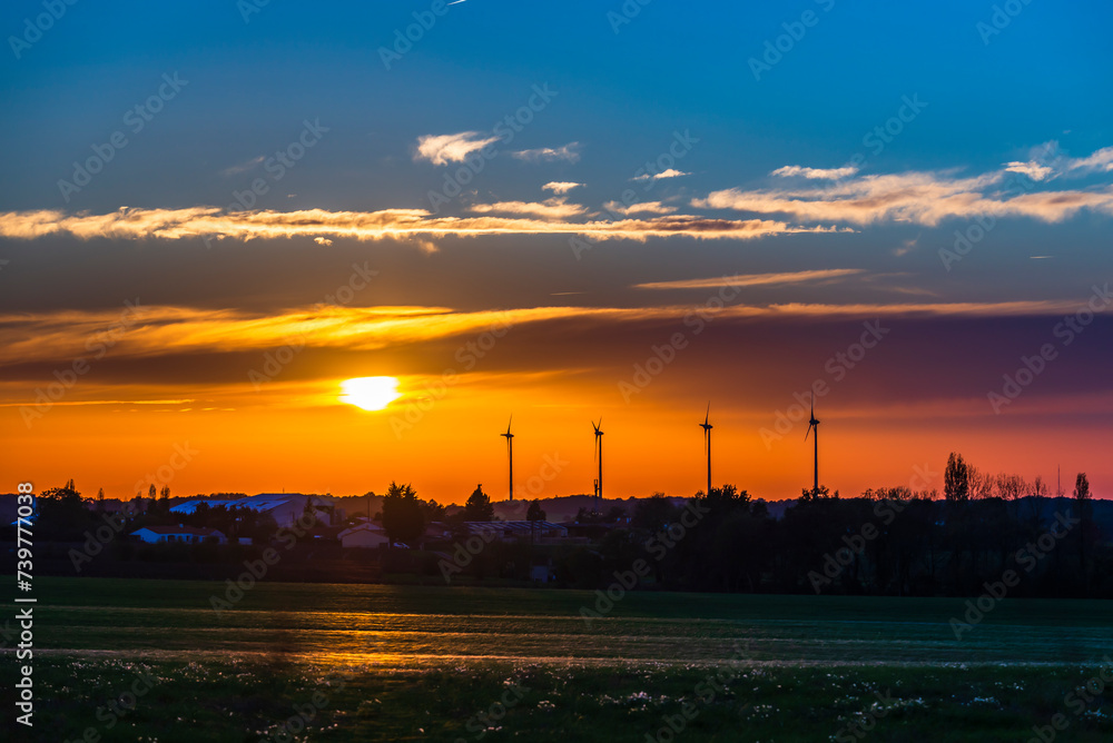A superb sunset over the wind turbines of the countryside of La Boissière-du-Doré.
