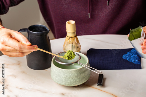 Cooking green matcha tea during the Japanese ceremony. Traditiobal kit, Bamboo whisk and beverage, spoon shashaku, heated tea bowl known as a chawan. Horizontal image. photo