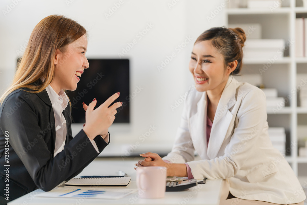 Two young Asian business woman talk, consult, discuss working with new startup project idea presentation analyze plan marketing and investment in the office. Two young Asian business woman talk, consult, discuss working with new startup project idea presentation analyze plan marketing and investment in the office.