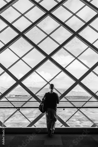 Travel, airport, woman waiting for a flight looking out the window, solo travel,faceless,airport transit area, travel experiences, authentic travel,bw, black and white, monochrome