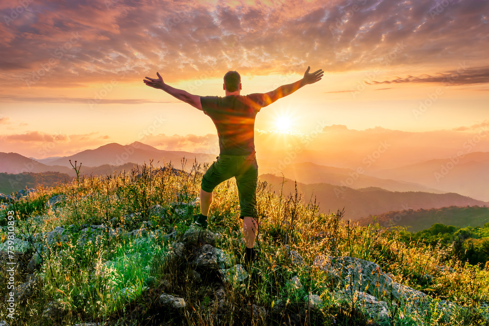 happy man watching amazing highland evening sunset, person delight with nature landscape