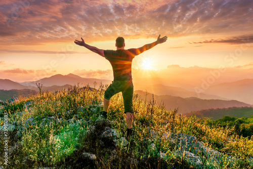 happy man watching amazing highland evening sunset, person delight with nature landscape