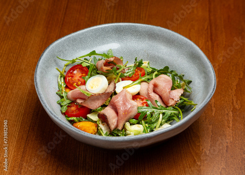 Salad with roast beef, vegetables and egg in a plate.