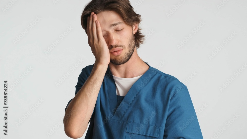 Fototapeta premium Tired Doctor Keeping Hand Face Feeling Sleepy After Hard Day Hospital Young Medical Worker Dressed Uniform Looking Weary White Background