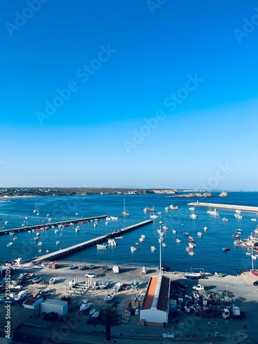 View to the small dock with yachts and boats, ocean coast, blue sky