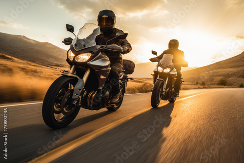 Two motorcyclists riding on a scenic open road at sunset