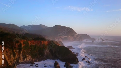 Bixby Creek Bridge Big Sur California aerial cinematic drone flight Pacific Ocean Nor Cal winter summer big wave swell crashing rugged coastline afternoon golden hour pink sunset slowly upward motion photo