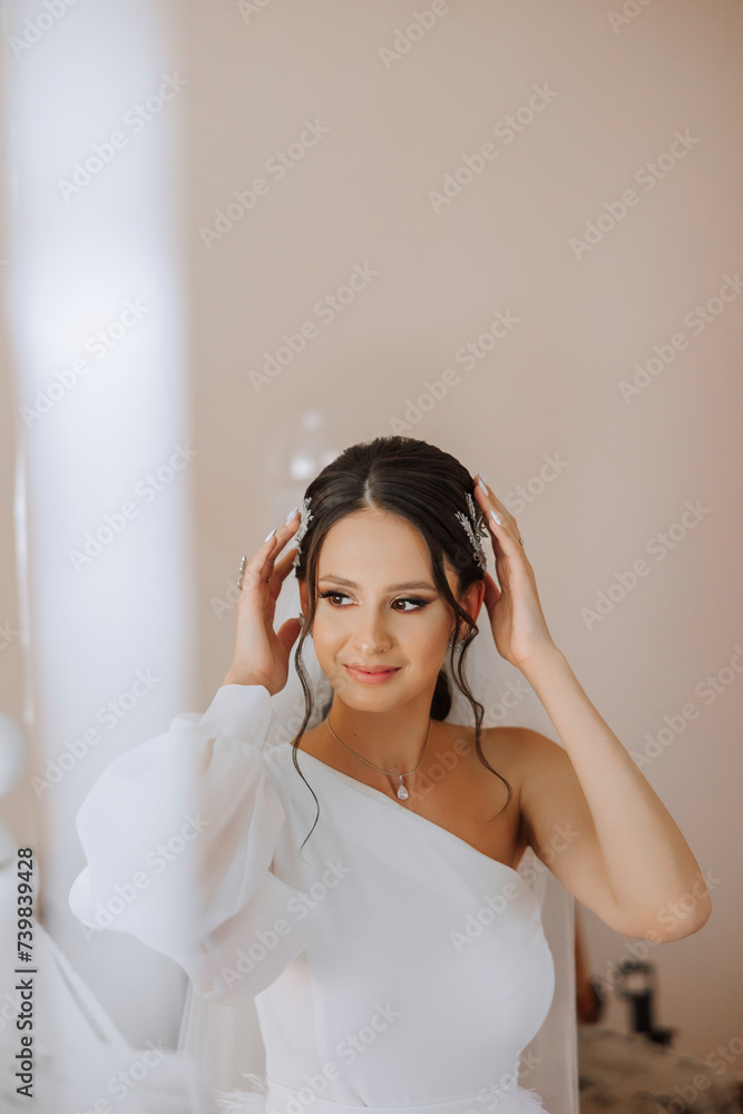 portrait of an incredibly beautiful girl bride in a white robe in the bedroom, the bride poses in the morning before the wedding ceremony. portrait of an incredibly beautiful girl bride in a white robe in the bedroom, the bride poses in the morning before the wedding ceremony.