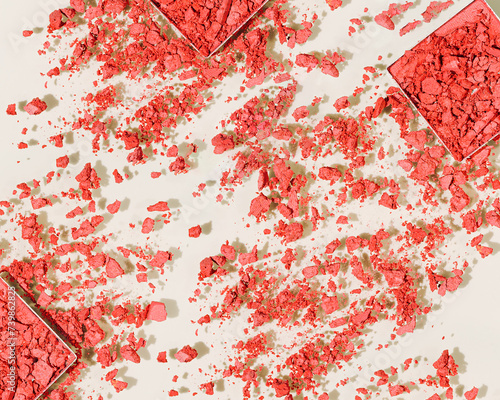 Red colored eyeshadows powder close-up texture, broken swatches of eye shadow powder or blusher as background, aesthetic top view, crumbling face makeup powder, woman cosmetics and beauty product