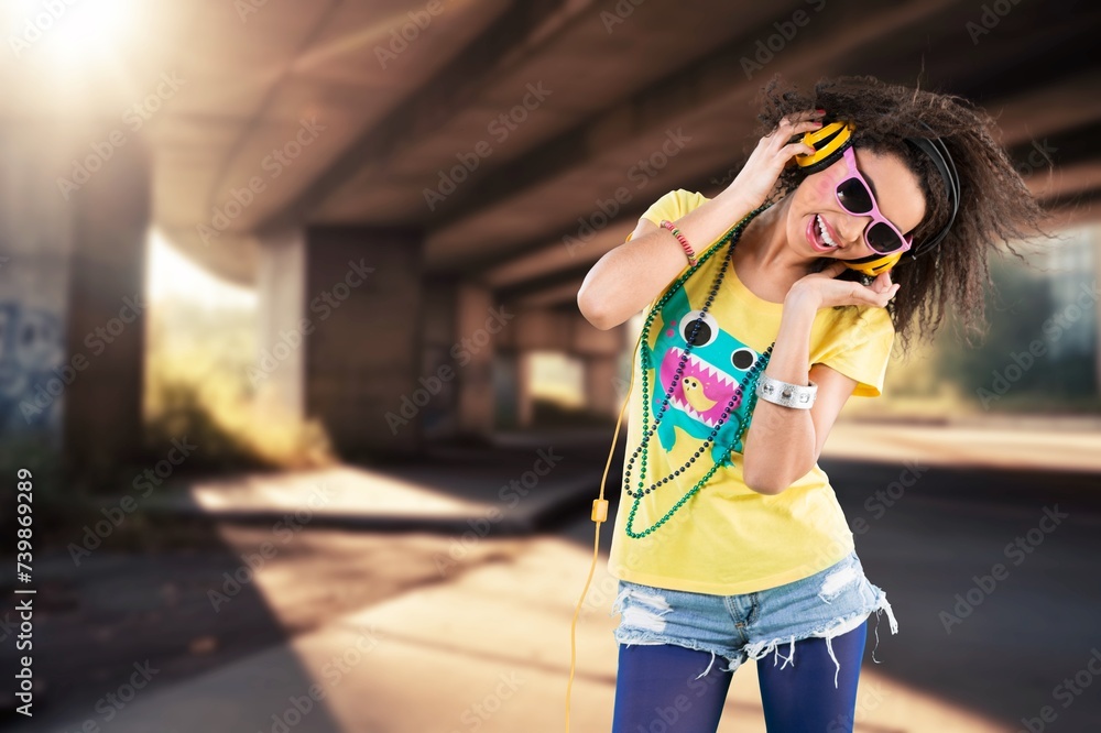 Dancing girl in city. listening music with headphones