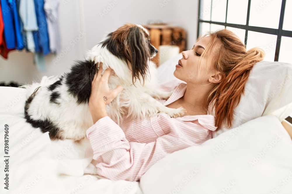 Young caucasian woman lying on bed with dog at bedroom Young caucasian woman lying on bed with dog at bedroom