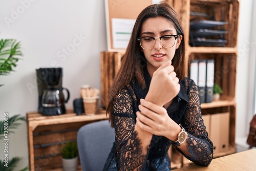 Young beautiful hispanic woman business worker suffering for wrist pain working at office