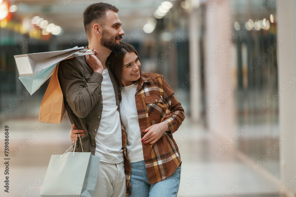 Fototapeta premium Embracing each other. Young couple are in supermarket together