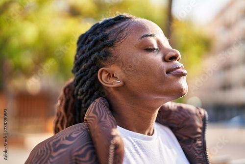 African american woman breathing with closed eyes at park