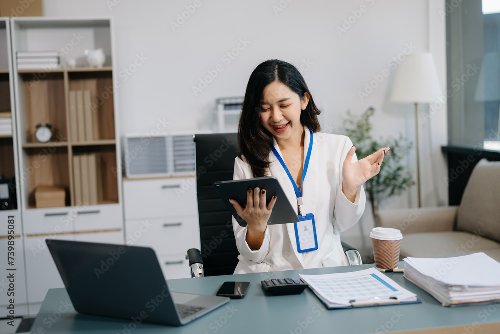 Asian Businesswoman Analyzing Finance on Tablet and Laptop at modern Office Desk Asian Businesswoman Analyzing Finance on Tablet and Laptop at modern Office Desk
