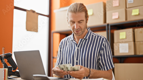 A middle-aged man counts money at his warehouse job, depicting a business and finance theme in an indoor setting.