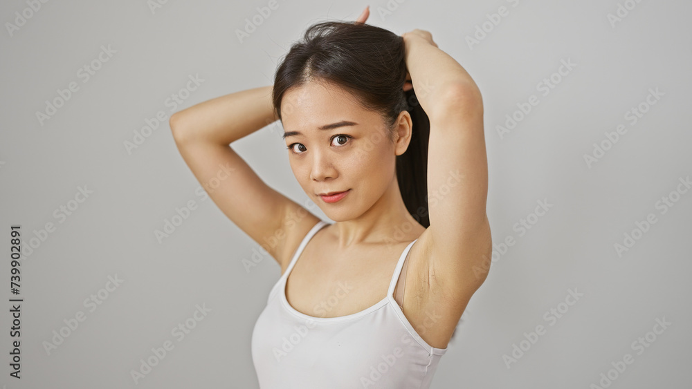 Portrait of a beautiful, young asian woman posing with her hair up against a white background. Portrait of a beautiful, young asian woman posing with her hair up against a white background.