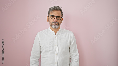 Chill vibes overload! young grey-haired hispanic man oozes cool, relaxed expression while standing, isolated over pink background. definitely that handsome adult male, rocking casual fashion! © Krakenimages.com