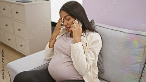 Fotografi Emotionally charged young woman, pregnant and touching belly, has a serious talk
