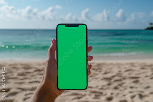 Mockup of an iPhone with a green screen, hand holding an iPhone, on the beach