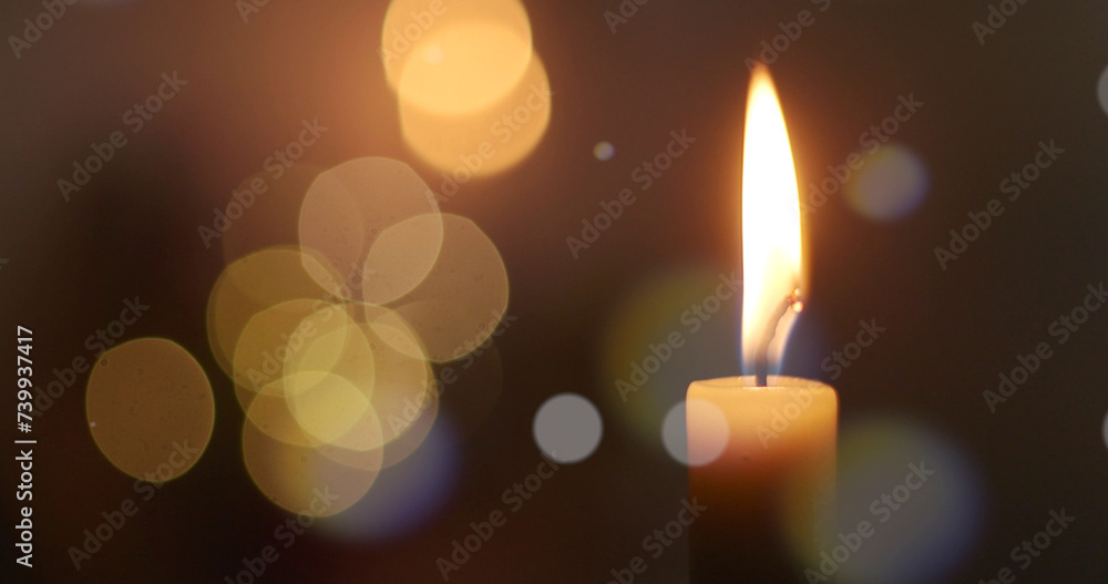 One candle flame at night with bokeh on a dark background One candle flame at night with bokeh on a dark background