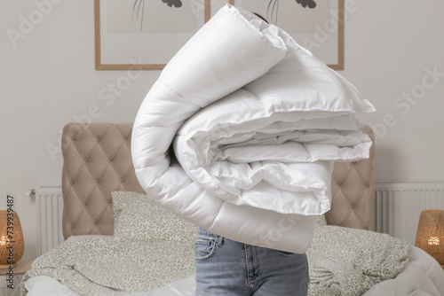 Fotografía Woman holding pile of soft white folded duvet and pillows at home in her bedroom, cozy domestic lifestyle, housewife cleaning, tidying up bedroom, housework chores concept