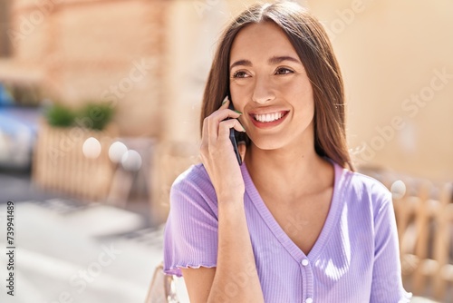 Young beautiful hispanic woman smiling confident talking on the smartphone at street