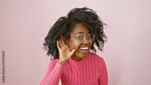 Photos Smiling african american woman with glasses, indoors against a pink background, portraying positivity and style