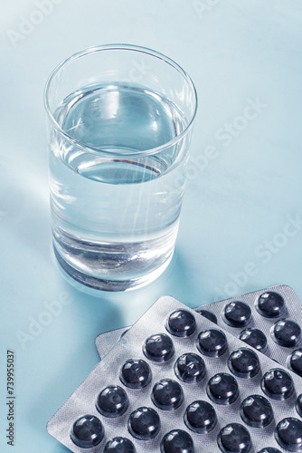Activated charcoal in tablets and a glass of water