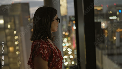 Canvas Print Beautiful hispanic businesswoman in glasses, captivating cityscape view from sky