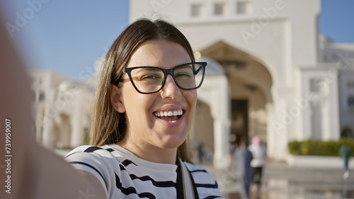 A smiling young woman enjoys tourism at qasr al watan palace in abu dhabi, uae.