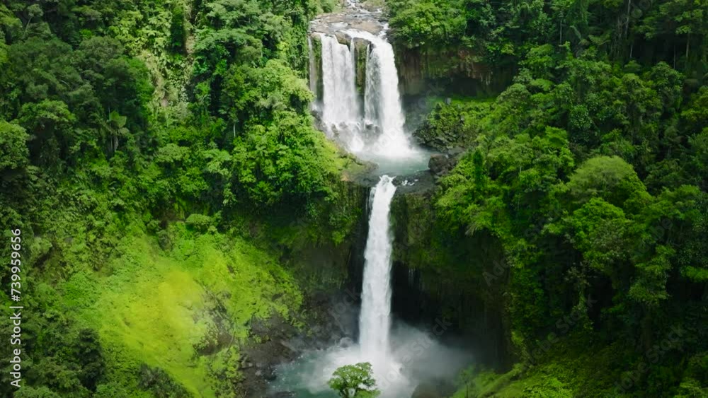 Two- tiered waterfall in mountain forest, slow motion view. Limunsudan Falls. Mindanao, Philippines. Two- tiered waterfall in mountain forest, slow motion view. Limunsudan Falls. Mindanao, Philippines.