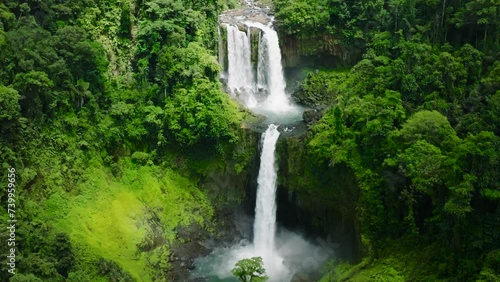 Two- tiered waterfall in mountain forest, slow motion view. Limunsudan Falls. Mindanao, Philippines. photo