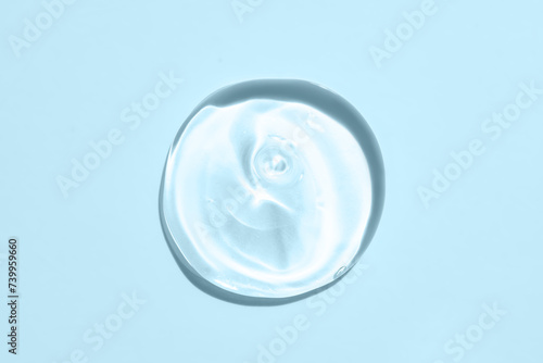 Squeezed cosmetic clear cream gel texture Isolated on blue background. Close up transparent serum drop smear