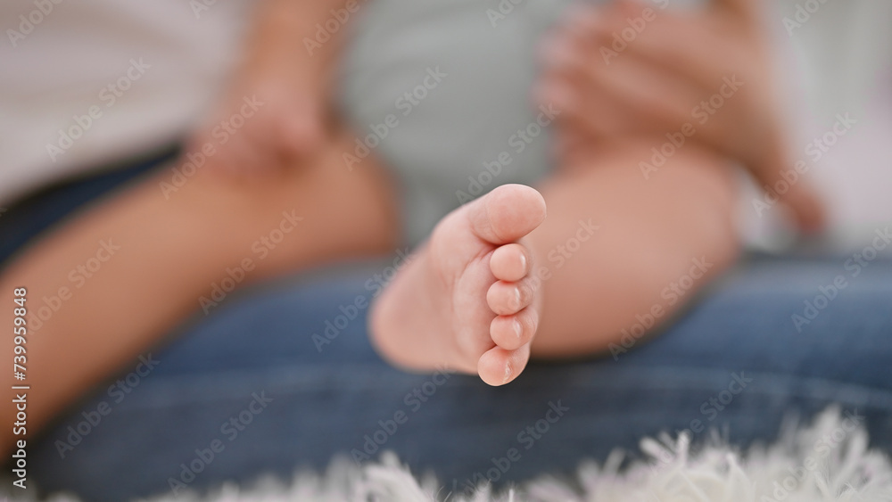 Loving mother sitting on the comfy living room sofa, enjoying beloved daughter's lovely infant charm in a cozy family home setting. Loving mother sitting on the comfy living room sofa, enjoying beloved daughter's lovely infant charm in a cozy family home setting.