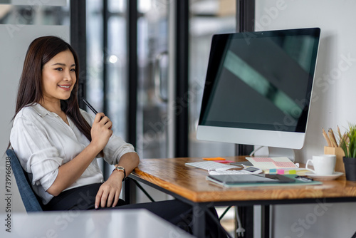 Asian business woman using computer with empty blank screen, sitting at workplace in the office, offering space for mockup on monitor. Male CEO showing place for online ad