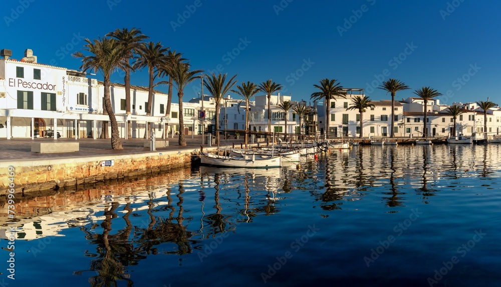 view of the village and harbour of Fornells in northern Menorca with reflections in the water