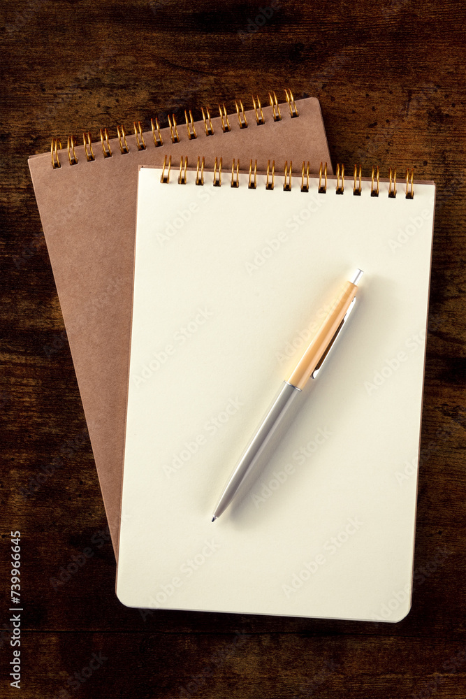 Notebook mockup with a pen, top shot on a rustic wooden desk Notebook mockup with a pen, top shot on a rustic wooden desk