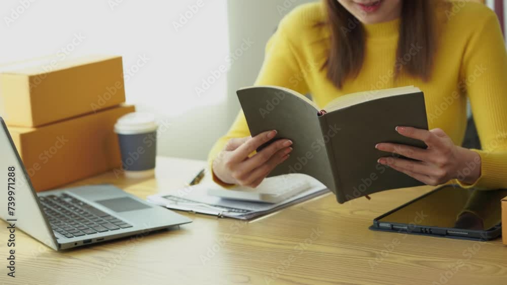 Starting a small business of an independent Asian woman using a laptop computer and calculator to calculate profit from SME business, package delivery Online marketing and SME concepts Starting a small business of an independent Asian woman using a laptop computer and calculator to calculate profit from SME business, package delivery Online marketing and SME concepts